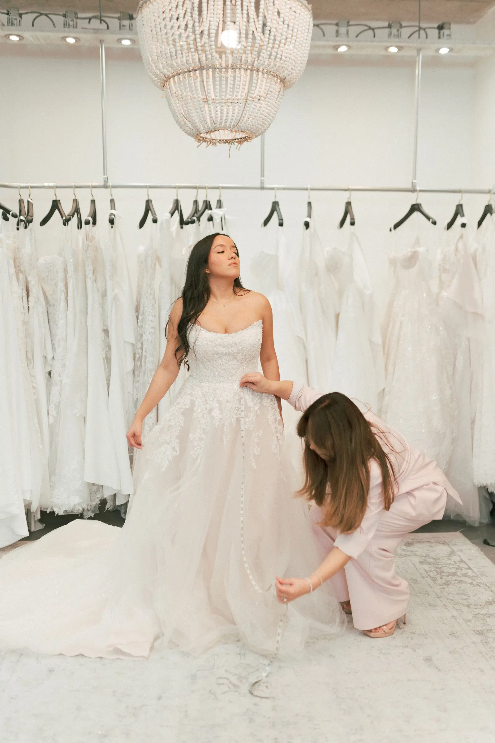 A consultant fitting a bride into a gown during an appointment at Cande Bridal Boutique in Kelowna, British Columbia